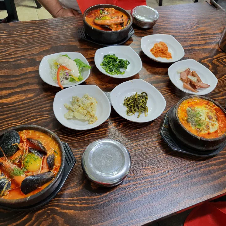 최일순짬뽕순두부 셀프바에서 가져온 기본 반찬과 순두부 뚝배기가 놓인 테이블