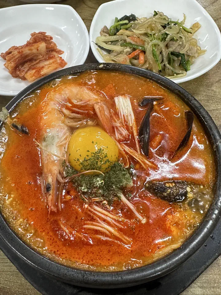 최일순짬뽕순두부 짬뽕순두부에 올라간 새우와 노른자 계란, 곁들여 나온 김치와 잡채