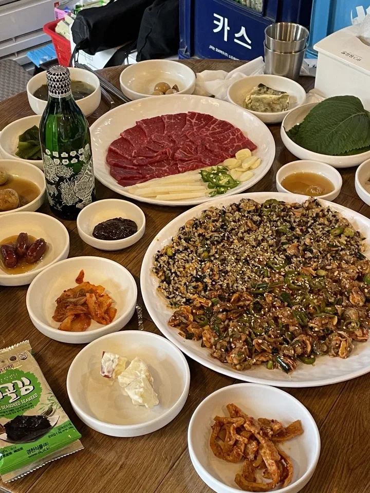 Dokdone’s cockle dish with a bottle of soju, seaweed soup and side dishes
