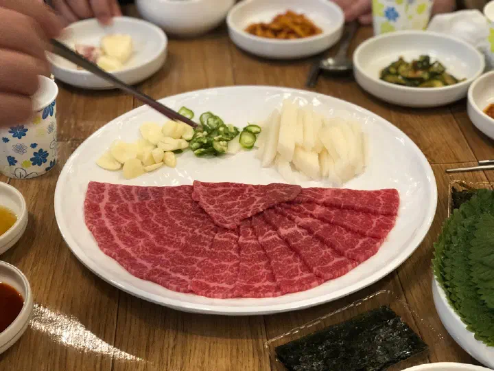 Banchan side dishes including pickled cucumber, kimchi and sesame oil dip at Dokdone