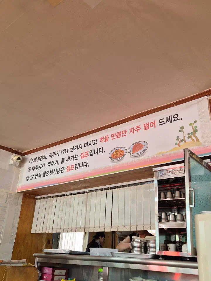 Korean sign at Geumcheon Kalguksu asking diners to serve themselves small portions of kimchi