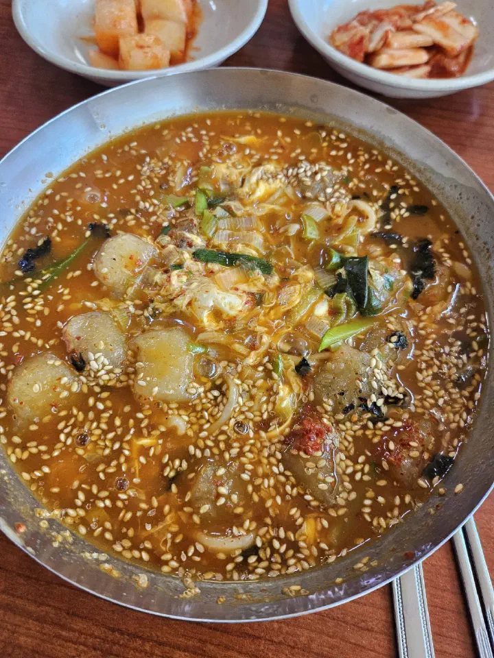Bowl of jang kalguksu ongsimi with chewy potato dumplings in spicy broth