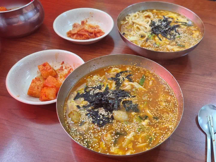 Jang kalguksu and jang kalguksu ongsimi served with cabbage kimchi and kkakdugi