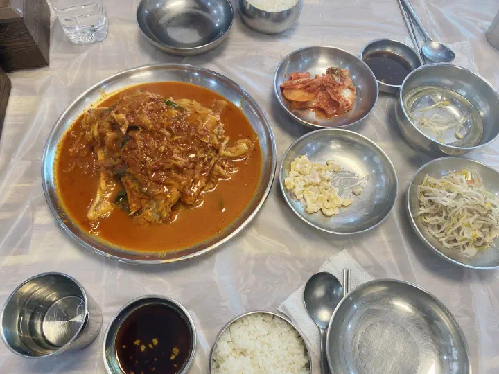 A full table of braised skate, rice and side dishes set for a group at Goseong Saengseonjjim