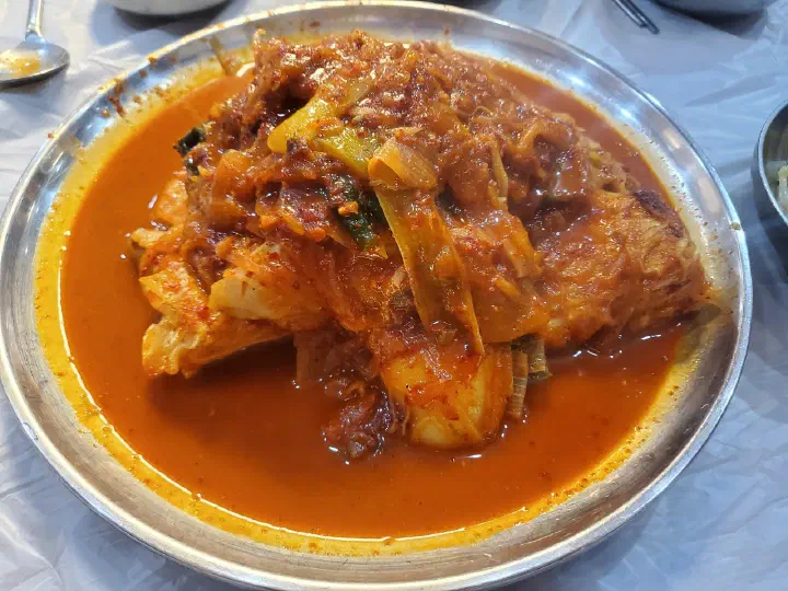 The loose, starch-free red chili sauce pooling around the braised skate