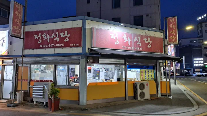 Exterior of Jeonghwa Sikdang in Okcheon-dong, Gangneung, with its red sign lit at night