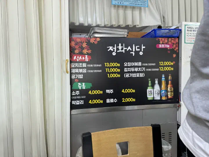 Jeonghwa Sikdang menu board showing hairtail 13,000 won and squid 12,000 won