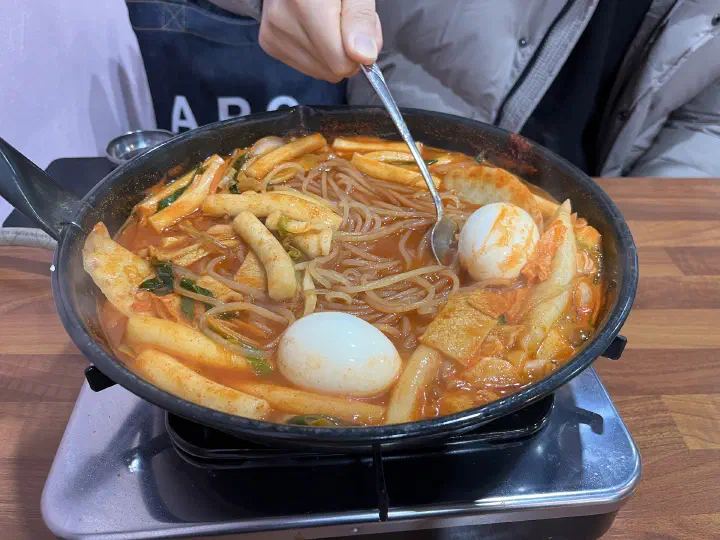 Dangmyeon glass noodles tangled among rice cakes and fish cake in the pot