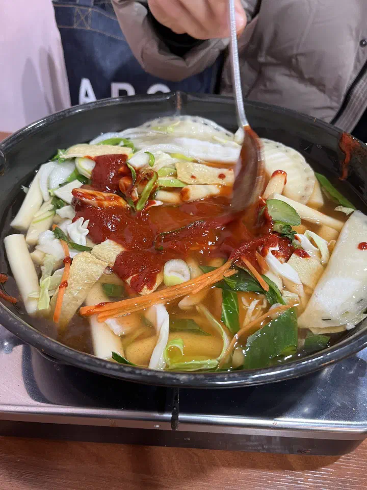 끓이기 전 떡과 어묵, 양배추 위에 고추장 양념이 올라간 즉석떡볶이 냄비