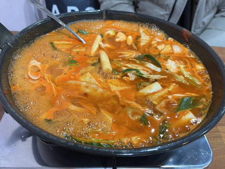 Jeukseok tteokbokki bubbling away on a portable gas burner at the table