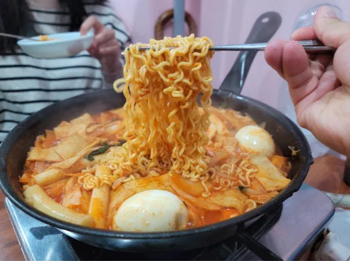 Ramyeon sari lifted out of the pot with chopsticks