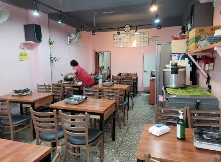 Interior of Sangatap Tteokbokki with wooden tables and a burner on each one