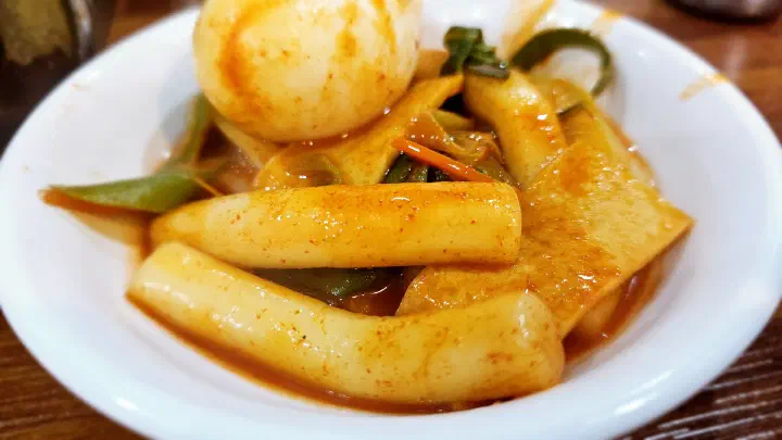 Wheat-flour rice cakes, fish cake and a boiled egg served on a small side plate