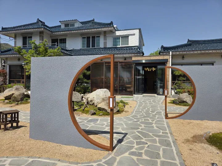 Round moon gate and stone path at the entrance of Cheolma Hanwoo Chowon