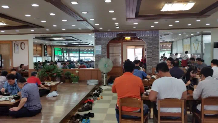 Spacious interior dining hall of Miryang Dwaeji Gukbap busy with customers