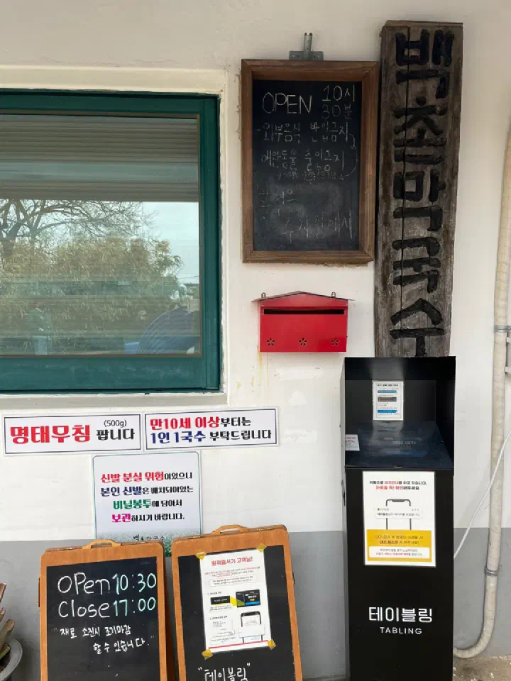 Baekchon Makguksu entrance notice board with hours and Tabling remote waitlist guide