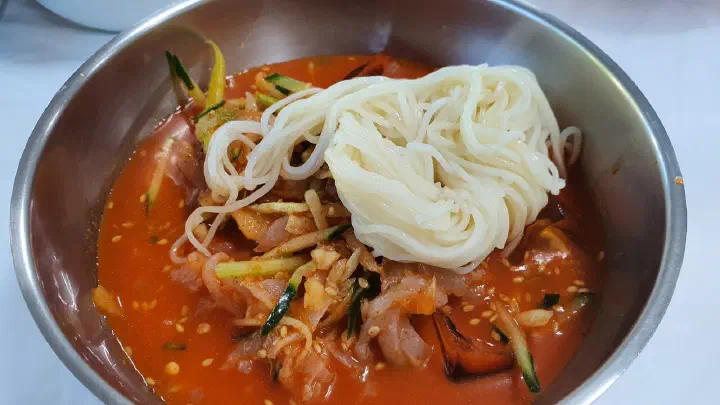 Somyeon wheat noodles added into a bowl of Gwangbeomine mulhoe