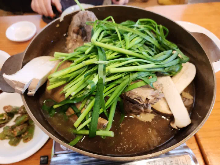 Free-range chicken baeksuk served with seasoned vegetable sides at Nakseonjae