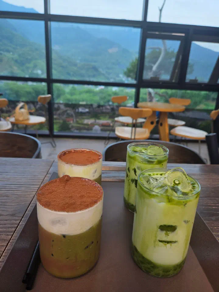 Jirisan green tea lattes on a window table with tea-field views at The Road 101