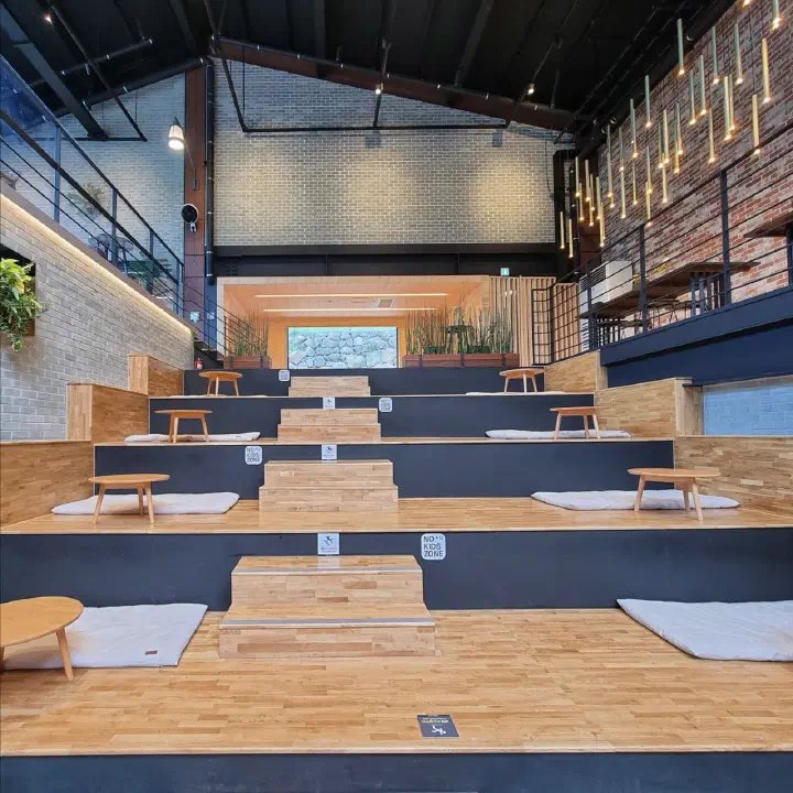 Stepped amphitheater-style seating beside the indoor pond at The Road 101