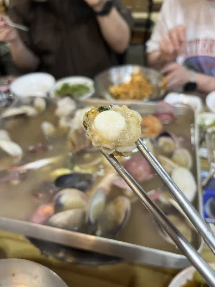 Plump scallop on chopsticks at Dapeojuneunjip