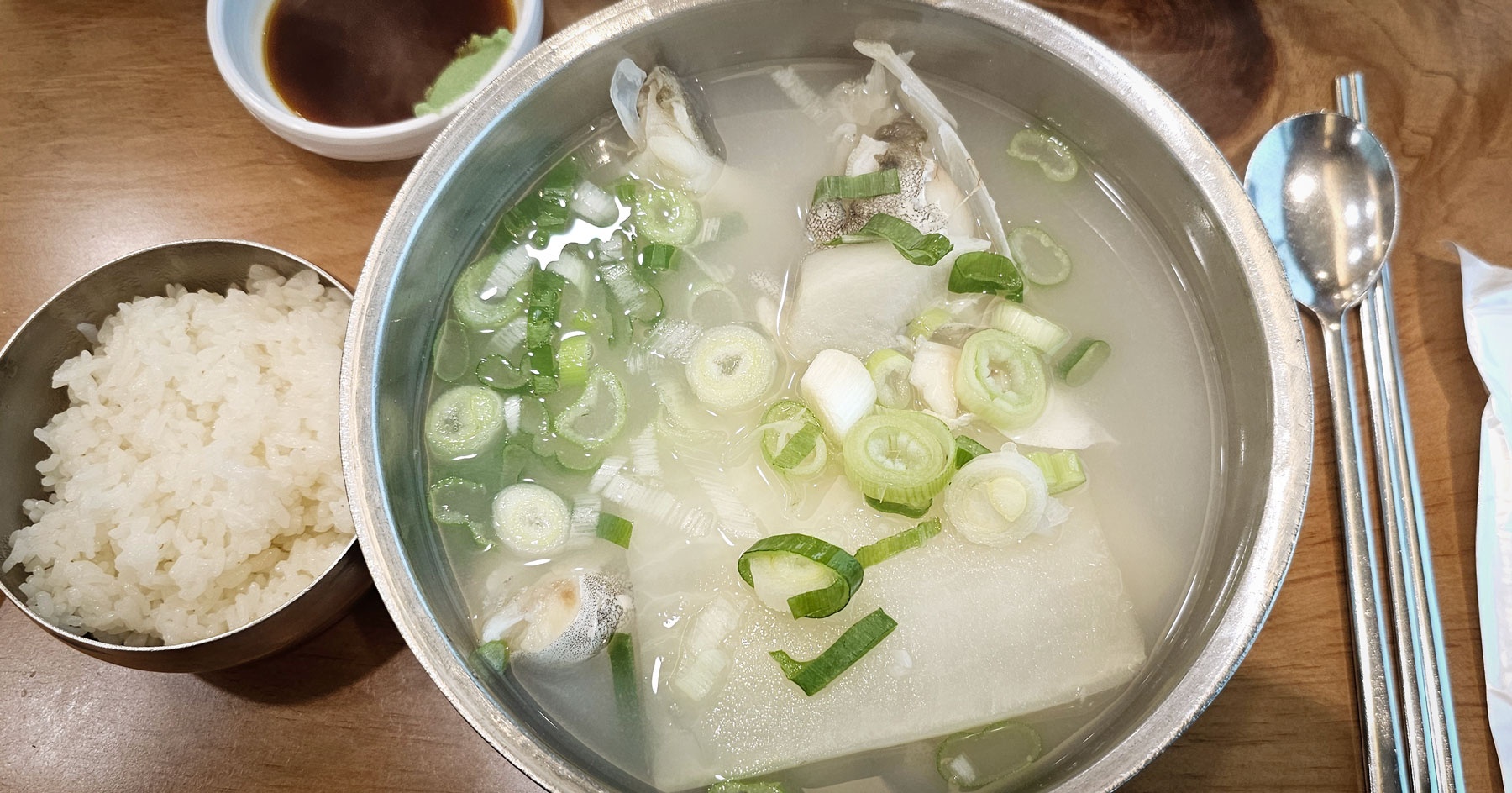 A full table setting of clear cod soup at Haeundae Giwajip Daegutang