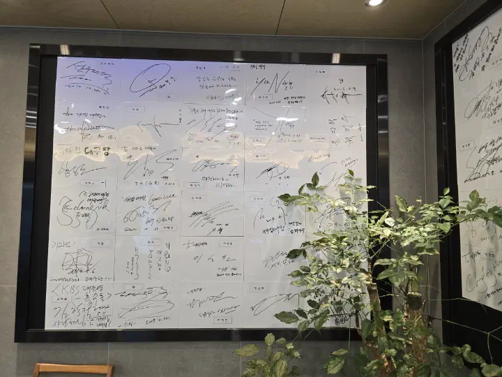 Wall of framed celebrity autographs at Haeundae Giwajip Daegutang