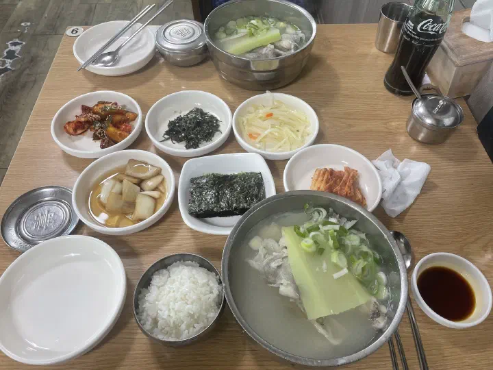 Full table setting at Haeundae Giwajip Daegutang with cod soup, rice, and side dishes