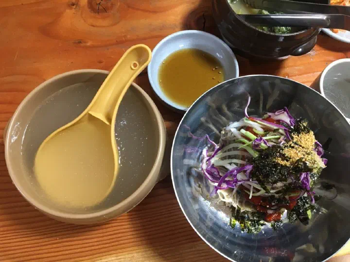 명태회와 채소를 올린 메밀막국수와 동치미 육수 한 그릇