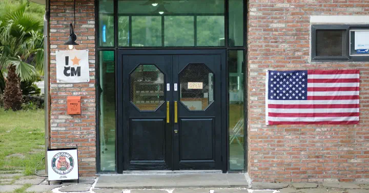 Black entrance door of Cookiemeow in Hyeopjae with an OPEN sign