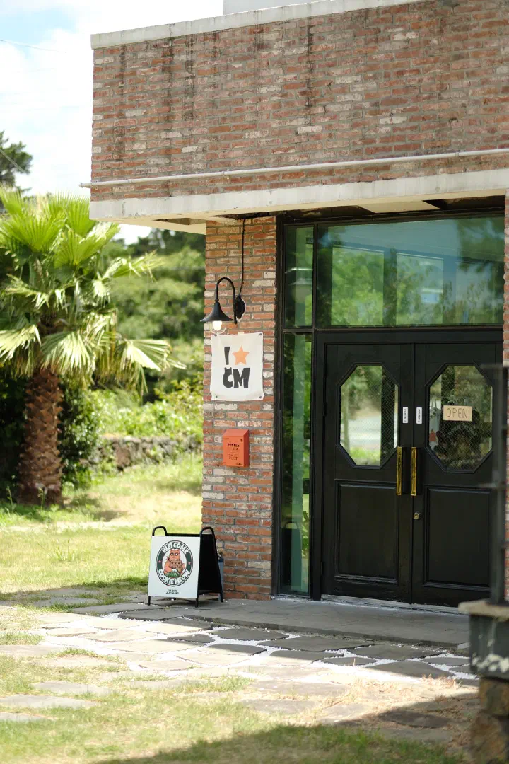 Cookiemeow storefront in a brick building with a garden near Hyeopjae Beach on Jeju