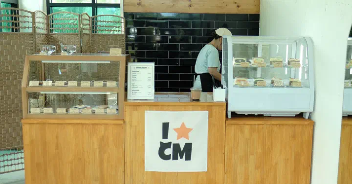 Interior counter at Cookiemeow with a display case of cakes and cookie pies