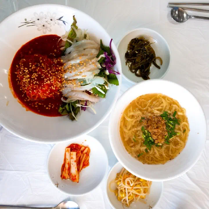 Gommak Sikdang’s signature dishes: a table set with hoe-guksu raw fish noodles and seongge-guksu sea urchin noodles