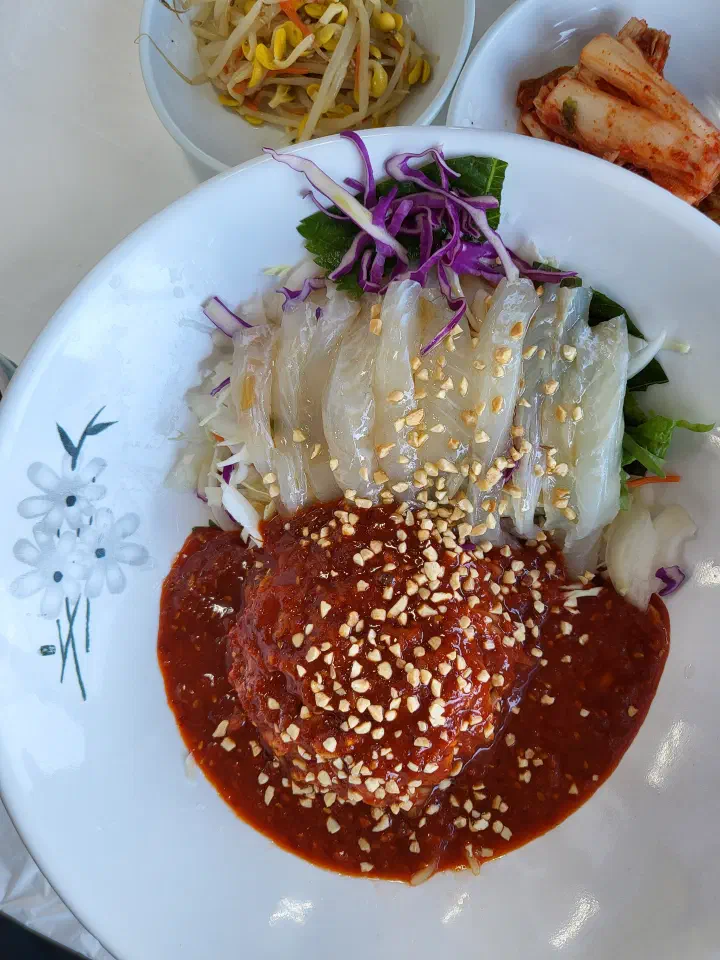 Gommak Sikdang hoe-guksu, thick raw fish slices over noodles with a sweet-and-sour red sauce and chopped peanuts