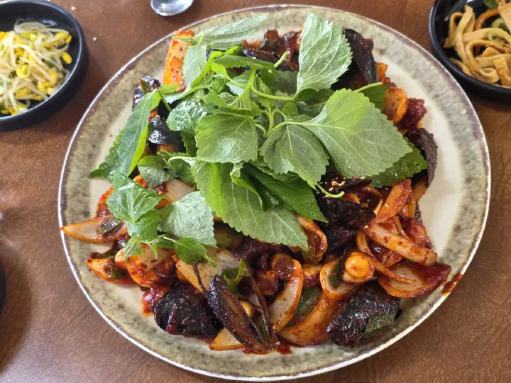 Close-up of tender rock octopus with onions and mussels in spicy red sauce