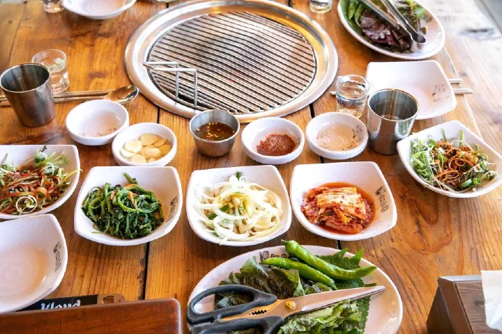 Table spread of Korean side dishes (banchan) served with black pork BBQ at Haeoreum, Jeju