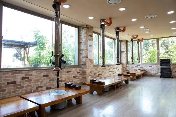 Interior of Haeoreum Restaurant with window-side seating and individual ventilation ducts at each table