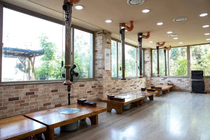 해오름식당 창가 좌석과 테이블별 개별 환풍 설비가 있는 매장 내부