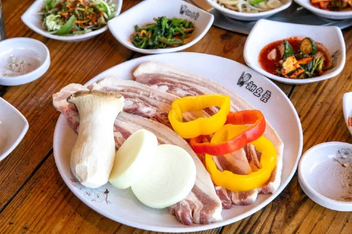 Raw Jeju black pork belly (ogeopsal) with king oyster mushroom, onion, and bell pepper at Haeoreum