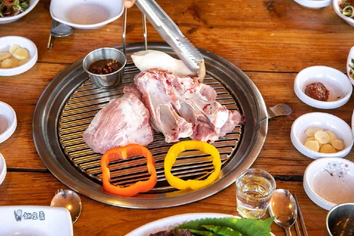 Raw black pork rib slab (yetnal tonggalbi) pre-seared on the charcoal grill at Haeoreum, Jeju