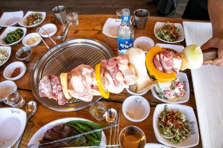 Giant black pork skewer with assorted special cuts and grilled vegetables and a bottle of Hallasan soju at Haeoreum