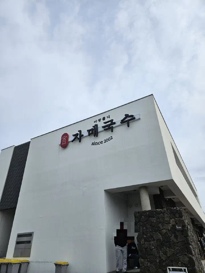 Exterior of the large Jamae Guksu main building in Jeju with its since 2002 signboard