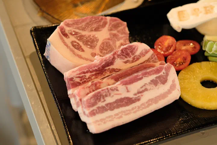 A plate of thick-cut raw Jeju black pork neck and five-layer belly