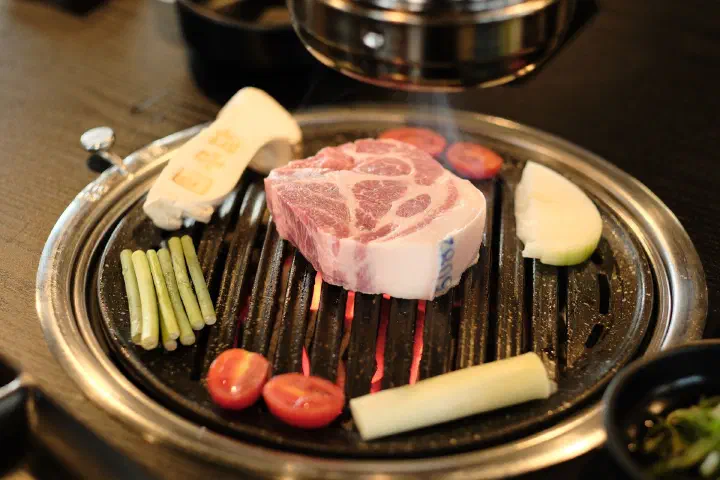 참숯 불판 위에 올려진 두툼한 제주 흑돼지 목살