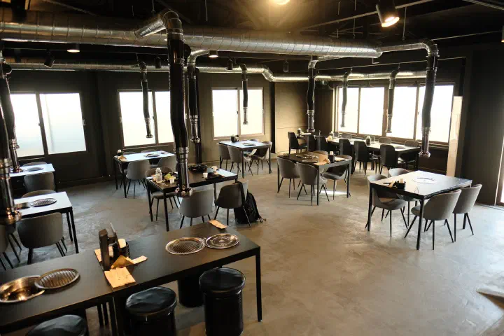 High-ceilinged, all-black dining room at Udam Jeju Jungmun