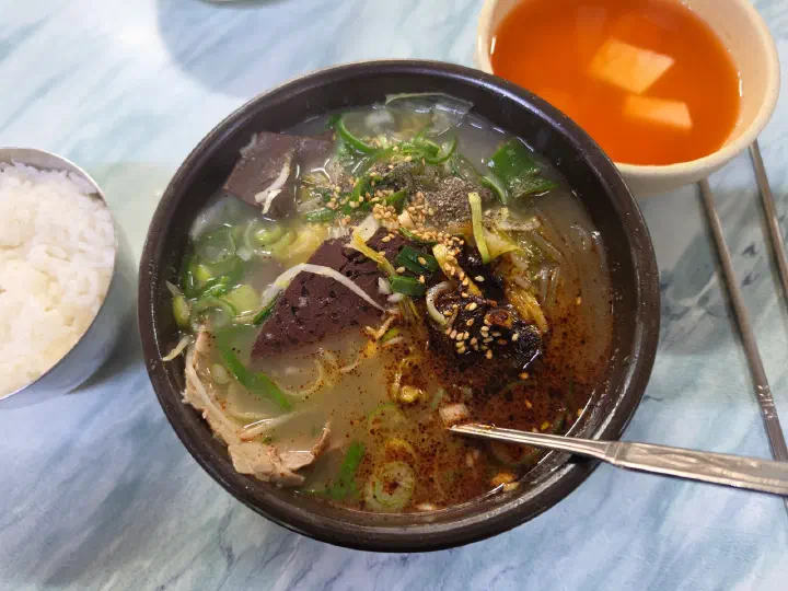 Bowl of Mipung Haejangguk sunji haejangguk with the red seasoning paste stirred in