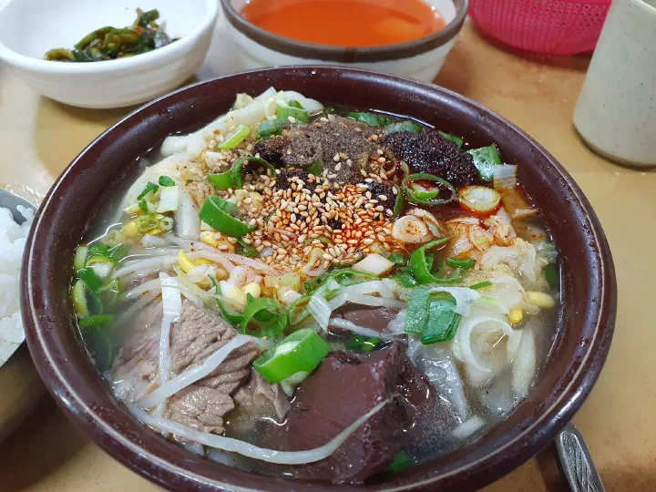Close-up of Mipung Haejangguk beef sunji haejangguk with brisket, sunji, bean sprouts, and glass noodles