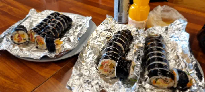 Several Oneunjeong gimbap rolls spread out on a table with drinks