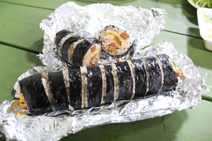 은박지 위에서 썰어 단면을 드러낸 오는정김밥 두 줄