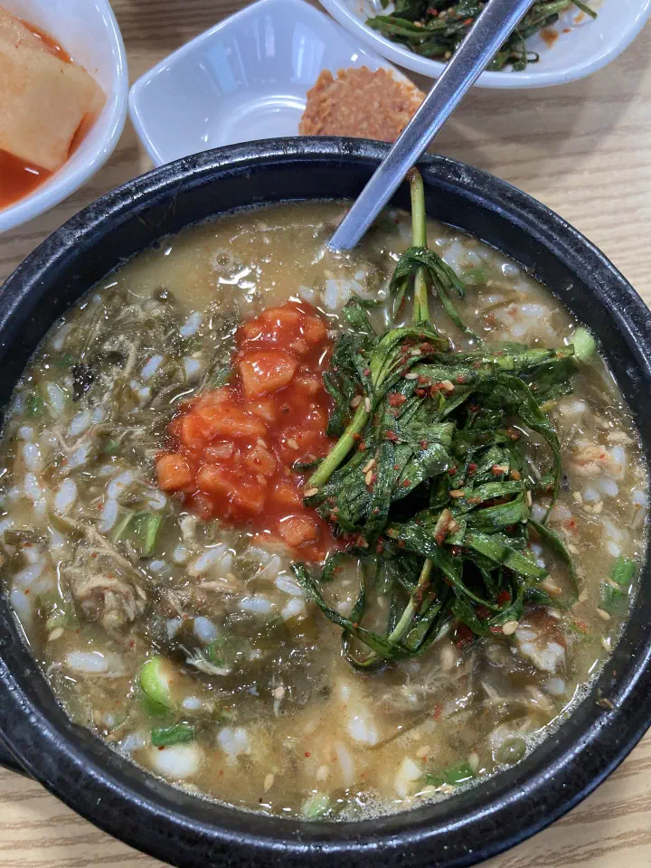 A thick bowl of gosari yukgaejang with rice stirred in and minced green chili on top